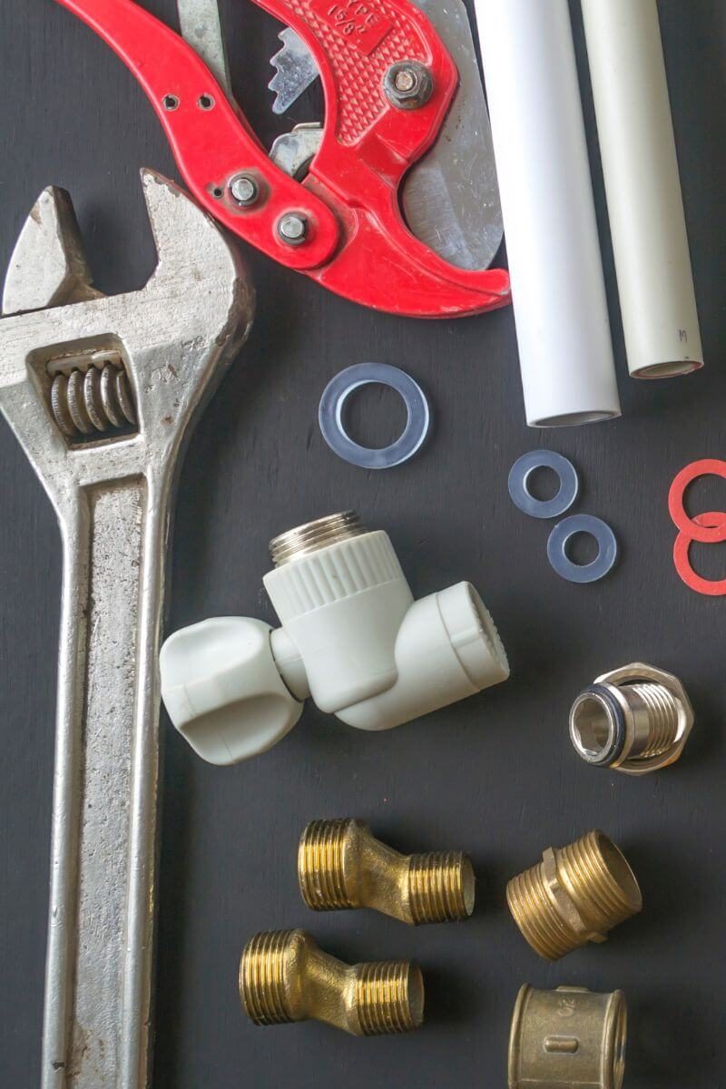 A written service estimate next to plumbing tools on a workbench